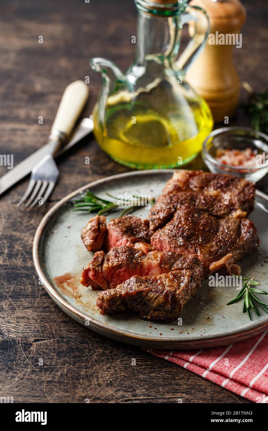 Fresh grilled beef steak Prime Black Angus Chuck roll steak sliced into pieces on dish on wooden table Stock Photo