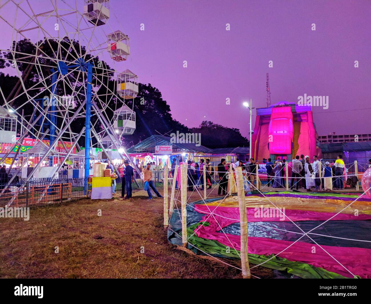 Night shot of a ferris wheel in exhibition fair.people and fairground