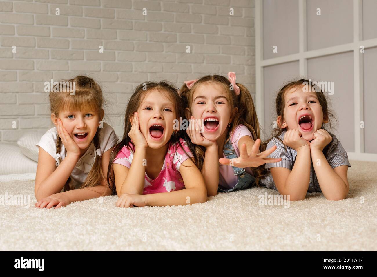 Two Happy Little Girls Sit In Group Of Friends Stock Photo Alamy