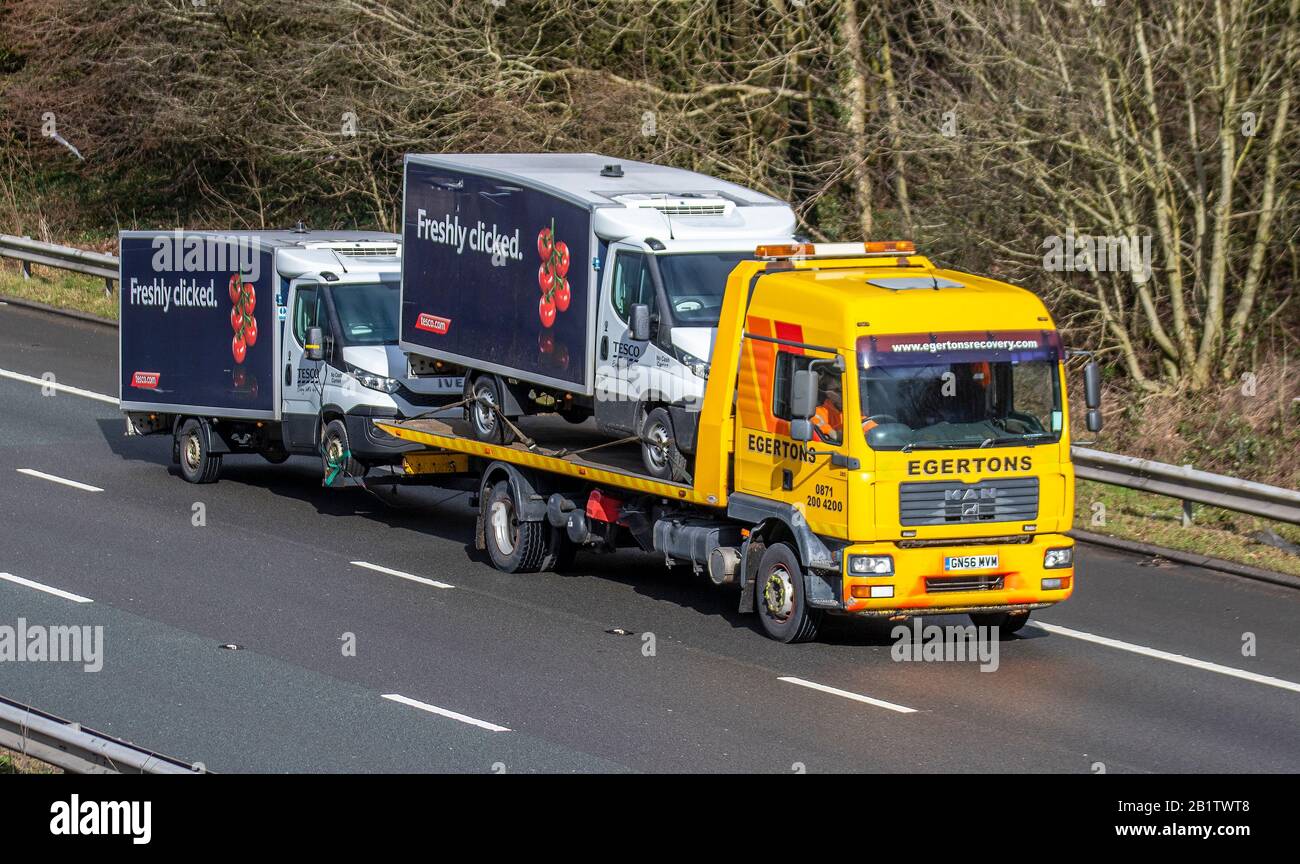 2007 yellow Egertons Haulage delivery trucks, lorry trailer, transportation, Tesco van breakdown recovery, vehicle carrier, 2017 Man Tg-M vehicle, European commercial transport, trucking industry, M61 at Manchester, UK Stock Photo