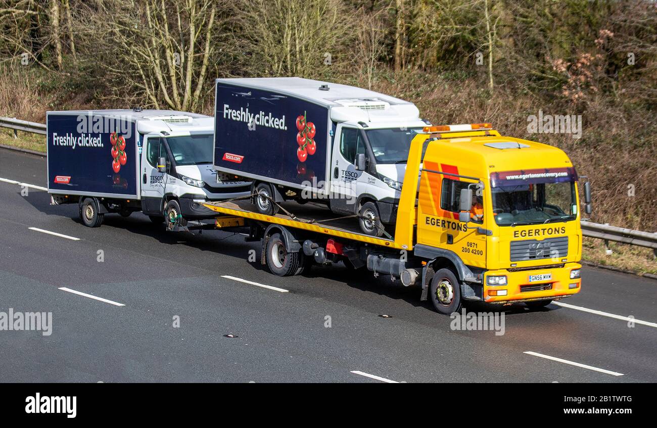 2007 yellow Egertons Haulage delivery trucks, lorry trailer, transportation, Tesco van breakdown recovery vehicle carrier, 2017 Man Tg-M vehicle, European commercial transport, trucking industry, M61 at Manchester, UK Stock Photo