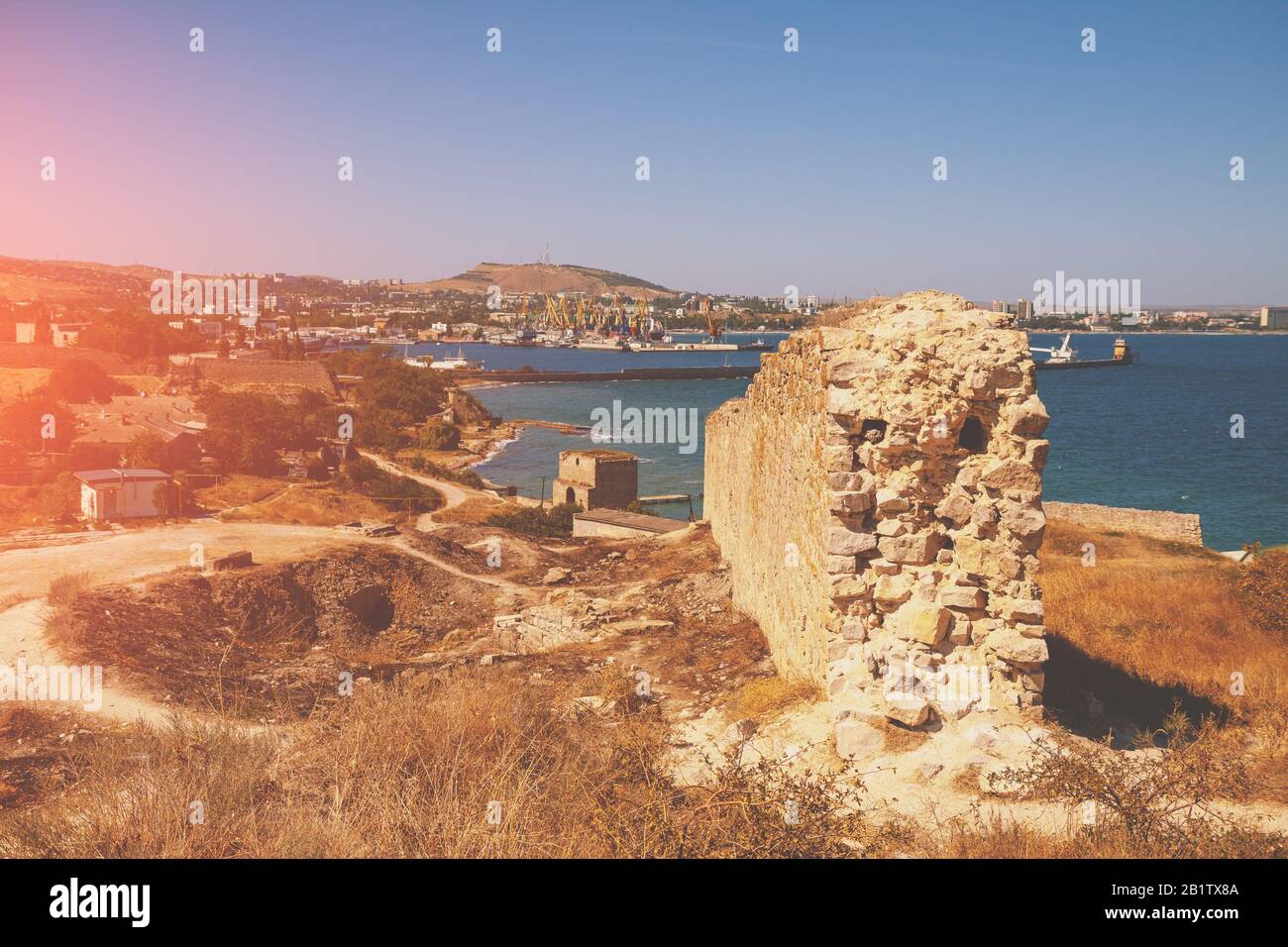 Ruins of the Genoese fortress of Caffa (Feodosia) Crimea. Rocky seashore. Sea nature landscape. View of the sea and Feodosia city from the mount. Port Stock Photo