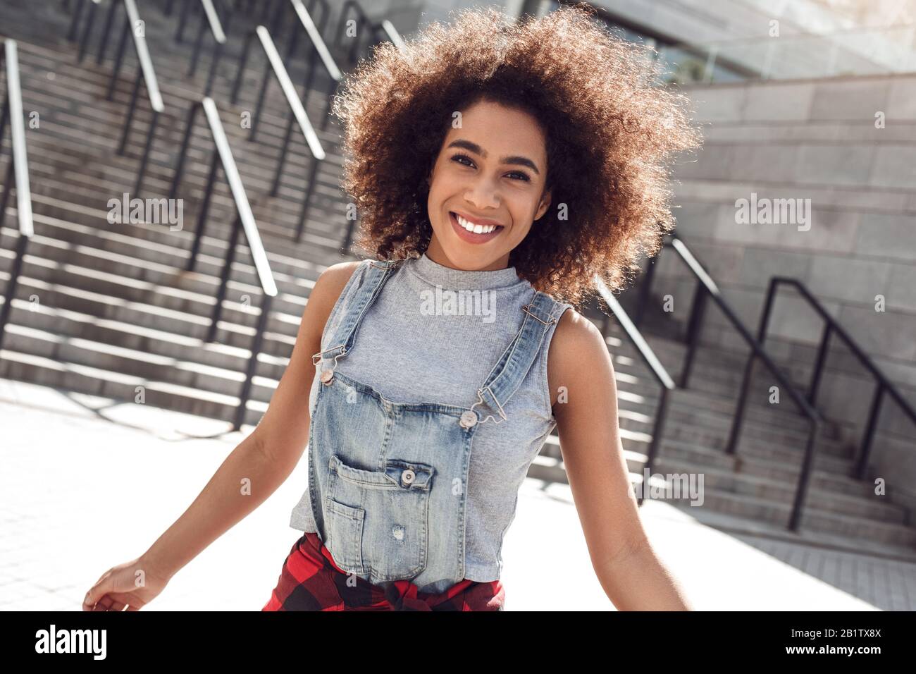 Young african american woman in the city street standing on stairs smiling cheerful Stock Photo