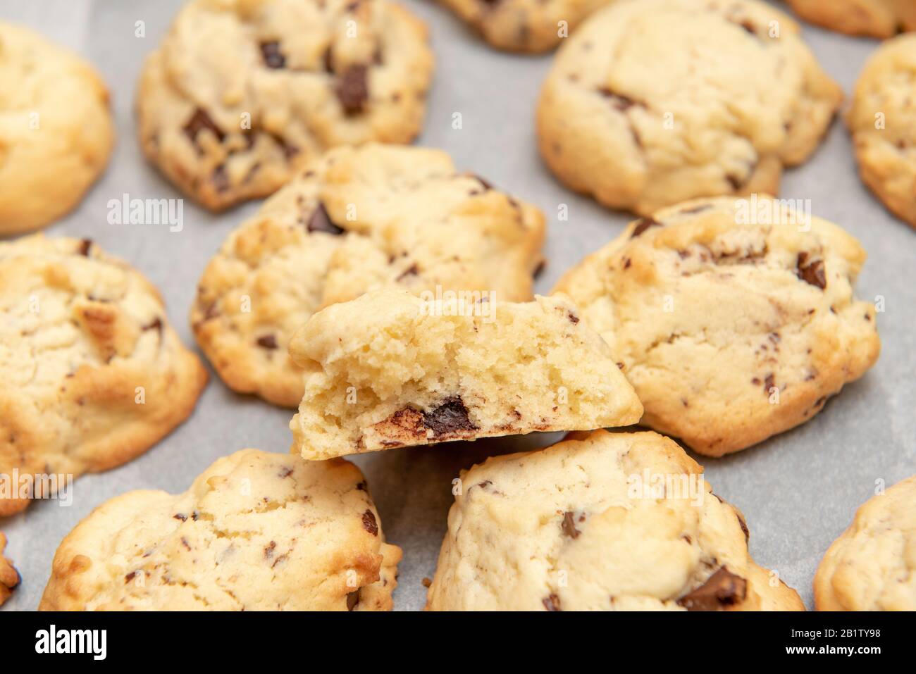 white cookies with pieces of chocolate on white backing paper Stock Photo