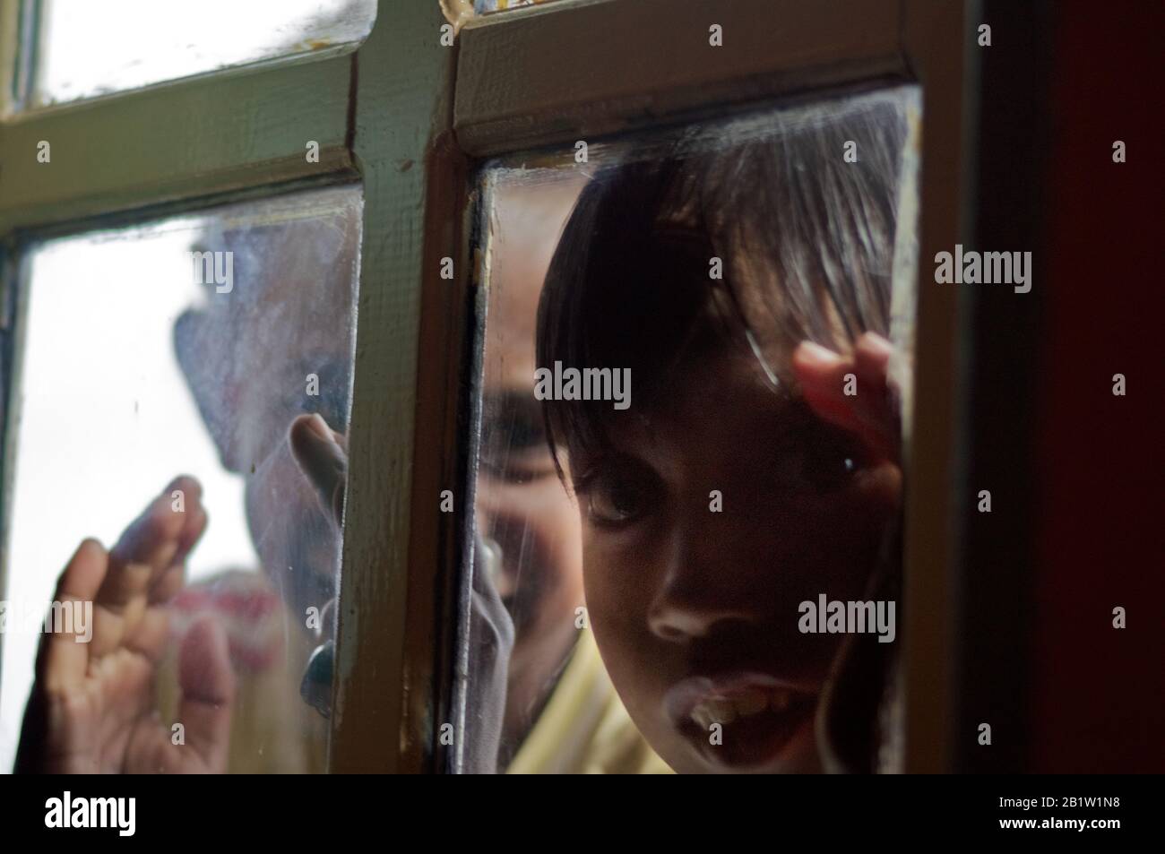 Children looking inside a house in Sorong harbor - Occidental Papua, Indonesia Stock Photo