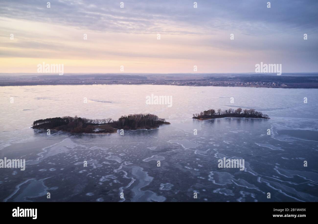 Small islands on frozen lake aerial drone view in winter time Stock Photo