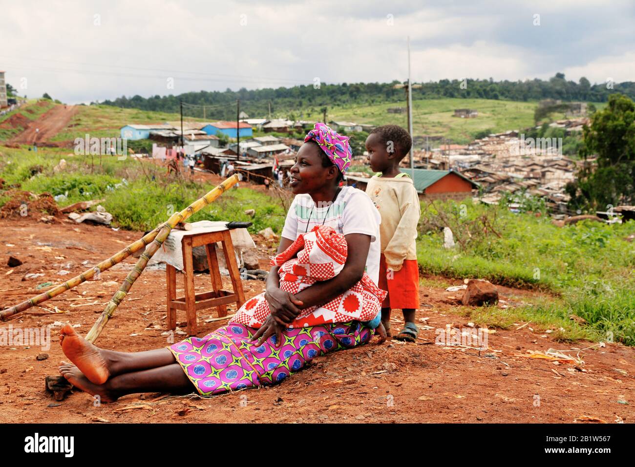 Women with baby sitting on the ground in slum earia Stock Photo