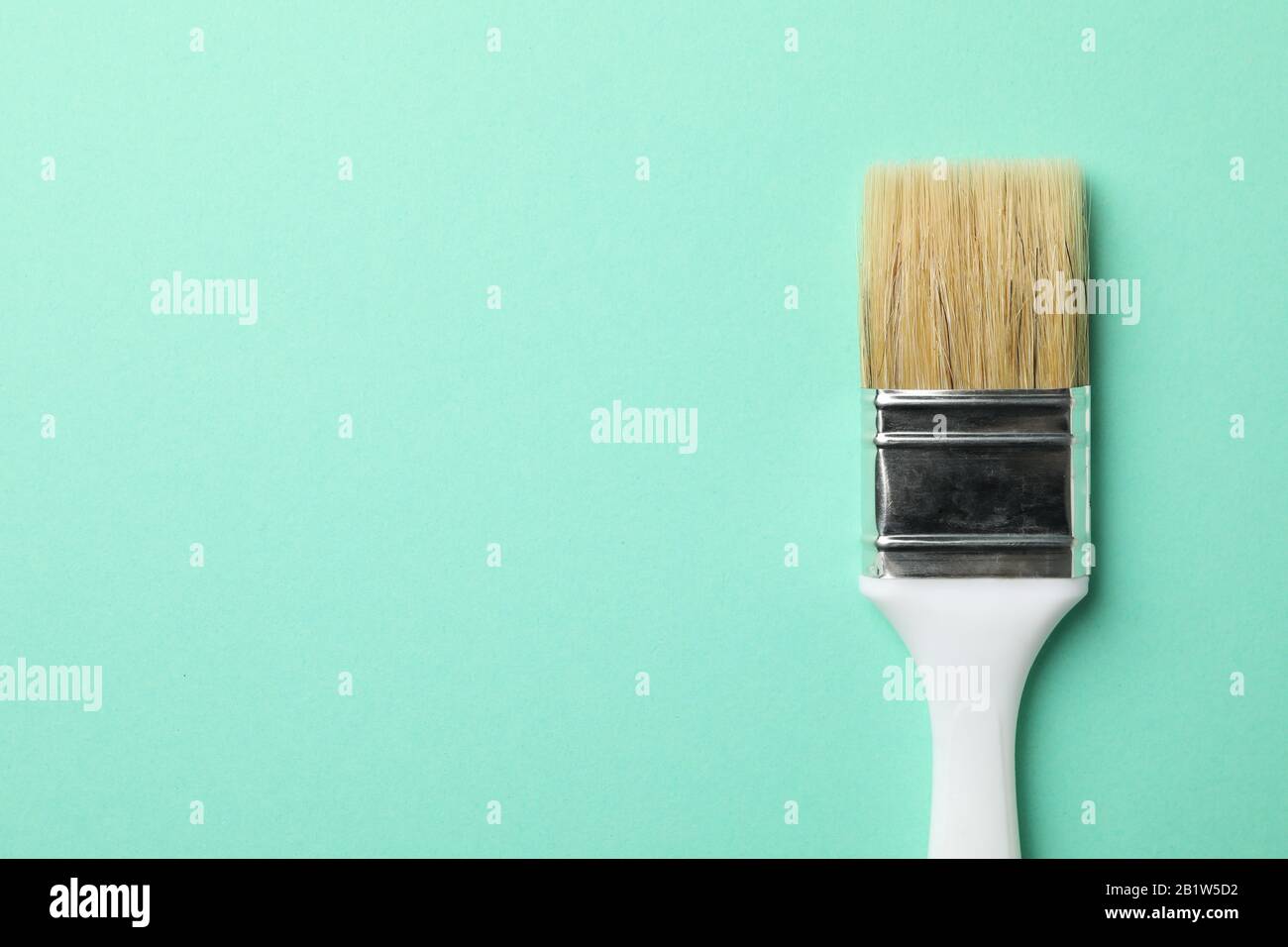 Paint brush on green background, space for text Stock Photo - Alamy
