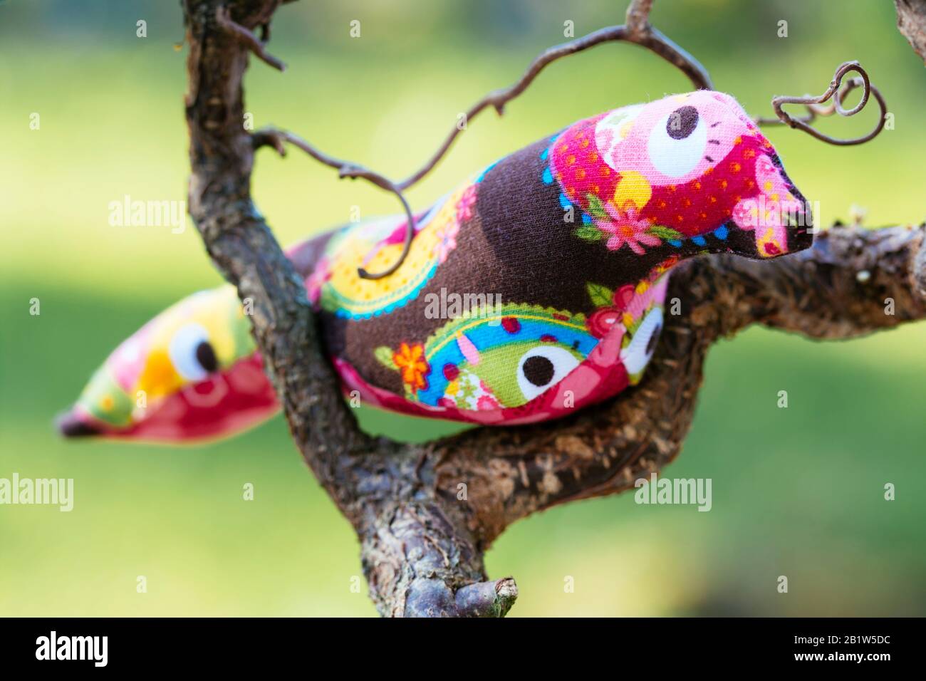Hand made bird softy on a branch in the garden Stock Photo