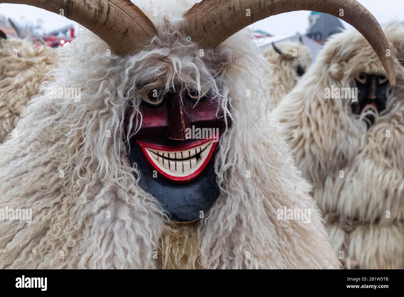 People wearing traditional Hungarian masks and costumes (Busos) at a carnival parade as part of holiday celebration Stock Photo