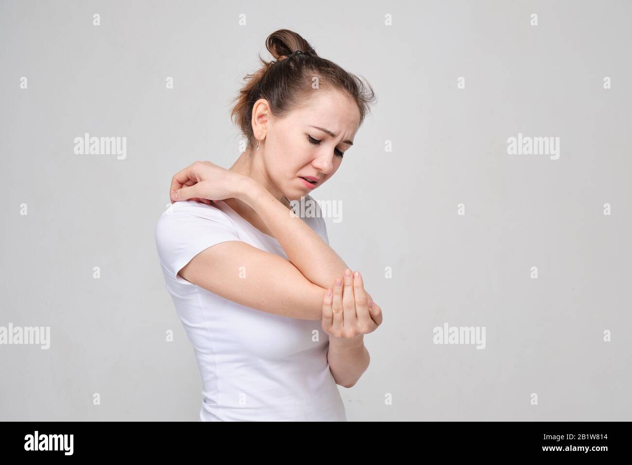 A girl in a white T-shirt massages her eyelids. The concept of severe pain  in front of the head. Close up Stock Photo - Alamy