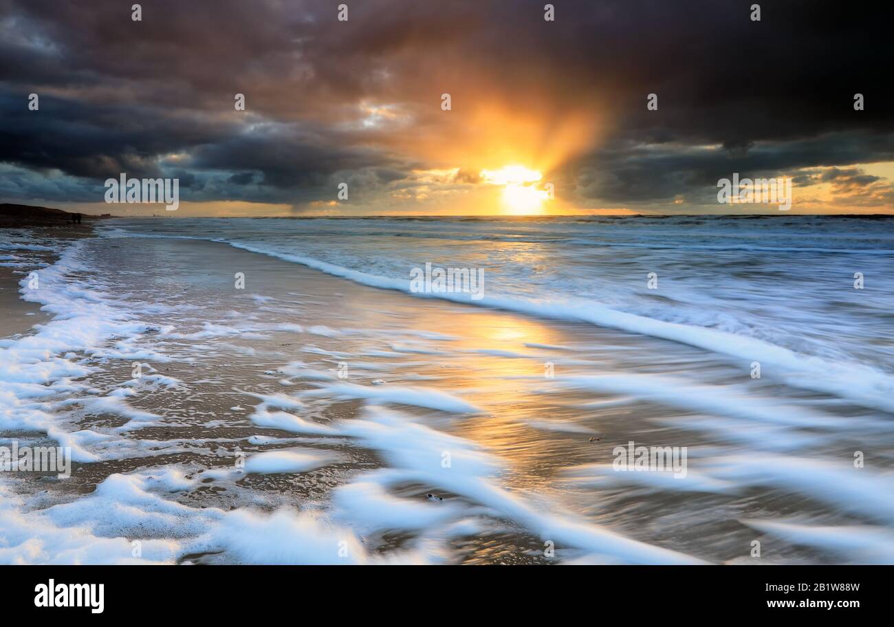 dramatic sunset over stormy North sea waves Stock Photo