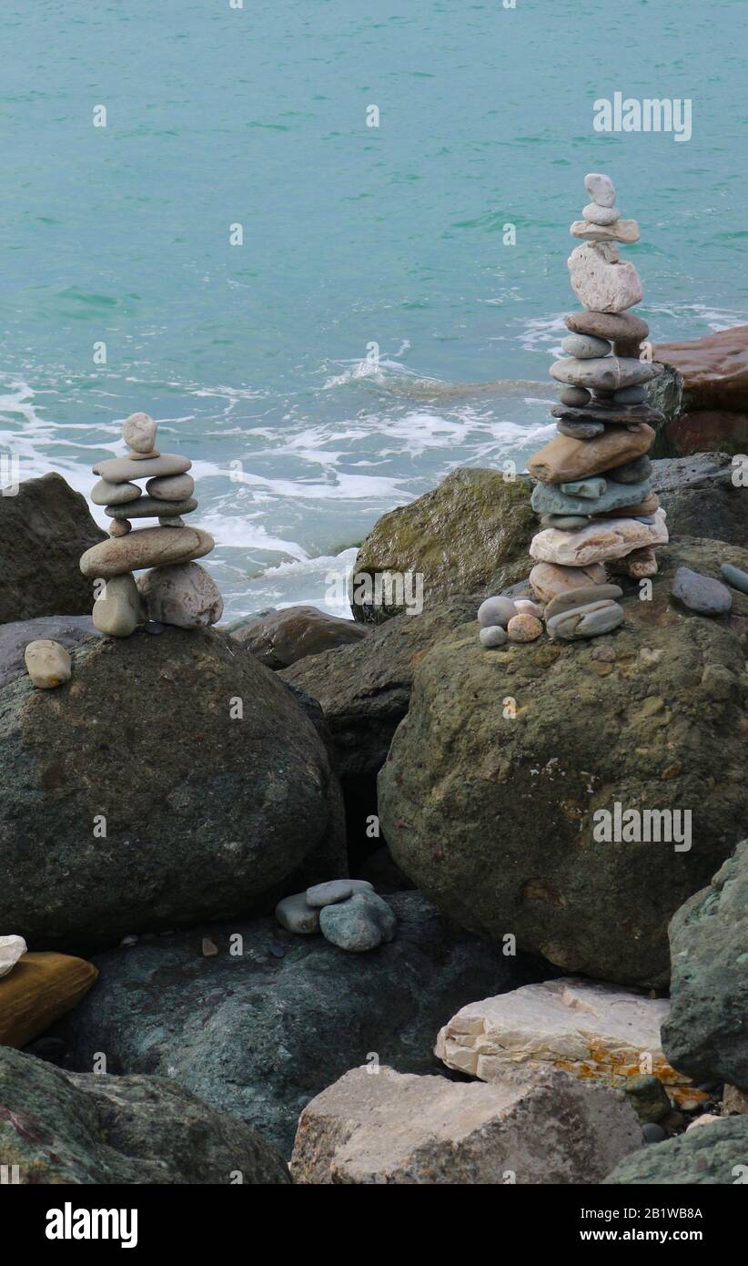 Stone cairn on seacoast. Big rocks and balanced pebbles stack. Relaxation, harmony, balance concept. Stock Photo
