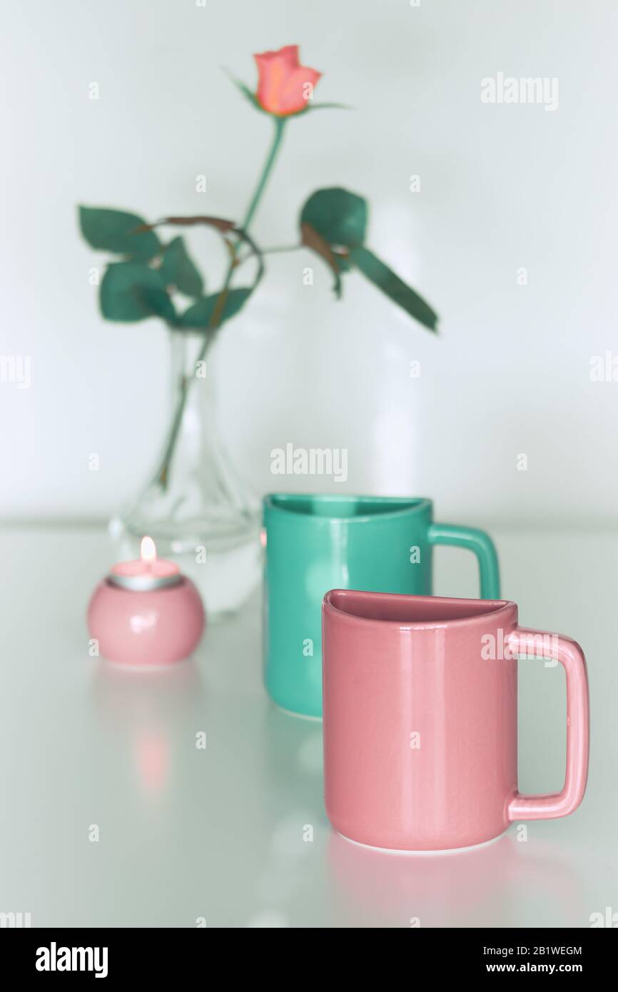 Pink rose flower, twin half tea mugs in pink and fresh mint or Biscay green. Minimalist design for your house in pastel colors. Modern interior decor, Stock Photo