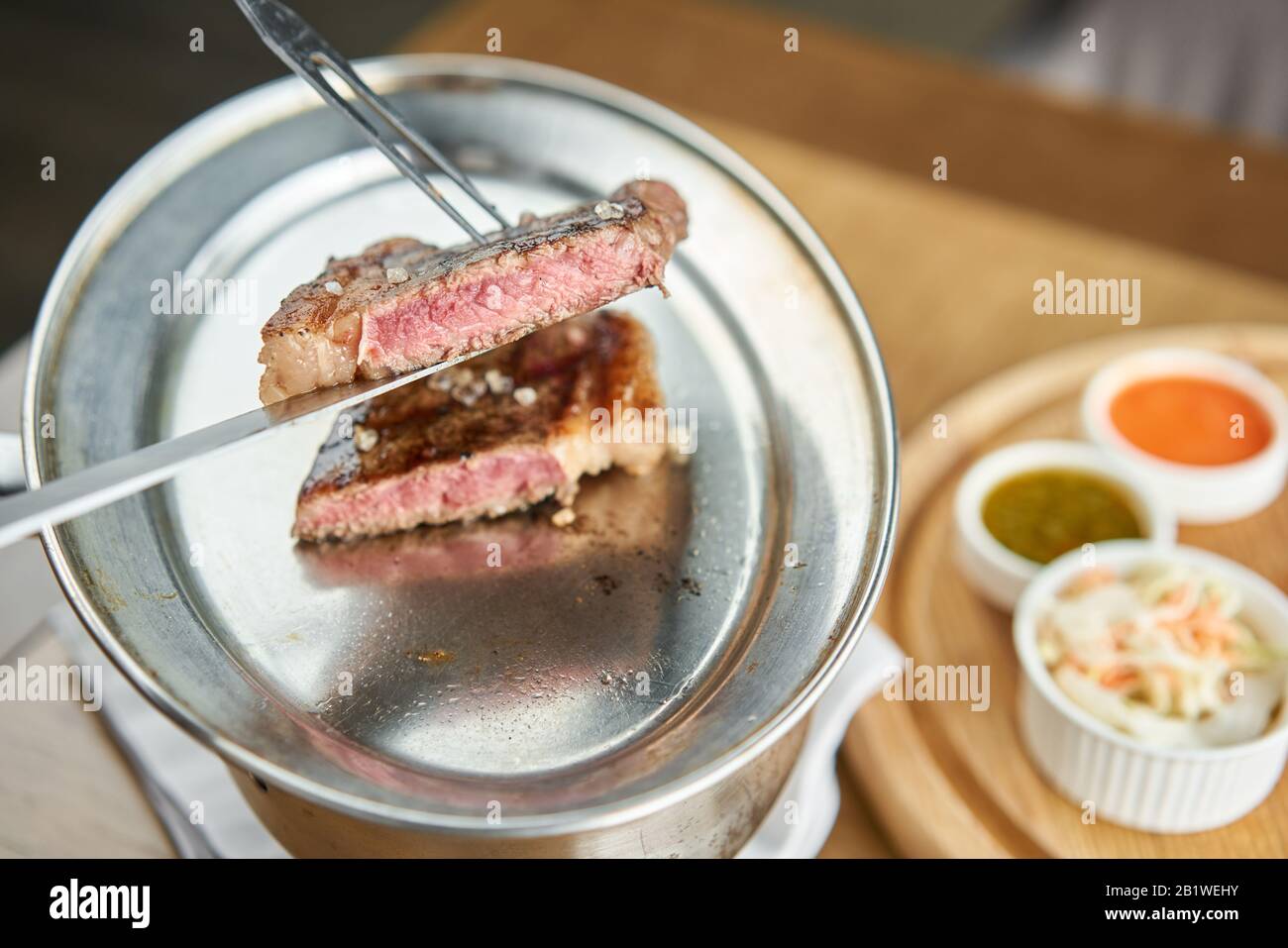 The waiter cut Grilled striploin steaks. The strip steak, also called a