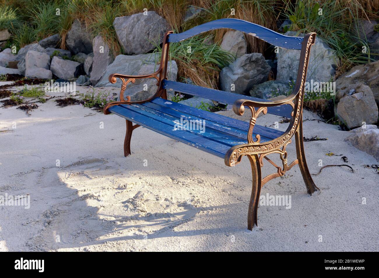 Beautiful old blue bench standing on sunny beach Stock Photo
