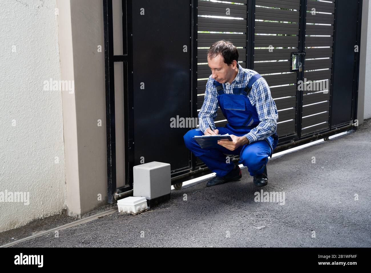 Repairman Fixing Broken Automatic Door In Building Stock Photo