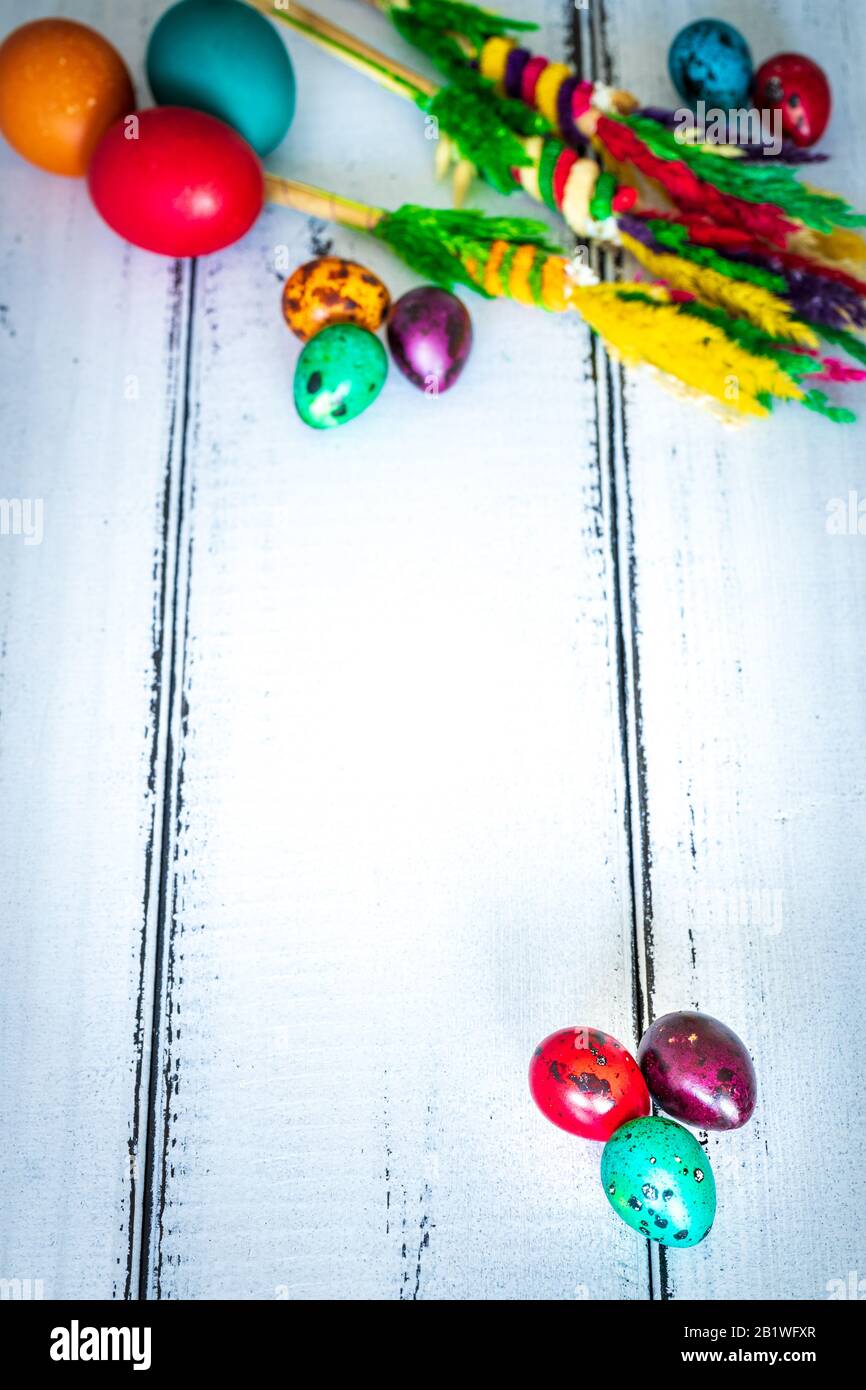 Happy Easter. Traditionally, colorfully painted eggs with decorations on bright, old boards with space for text. Stock Photo