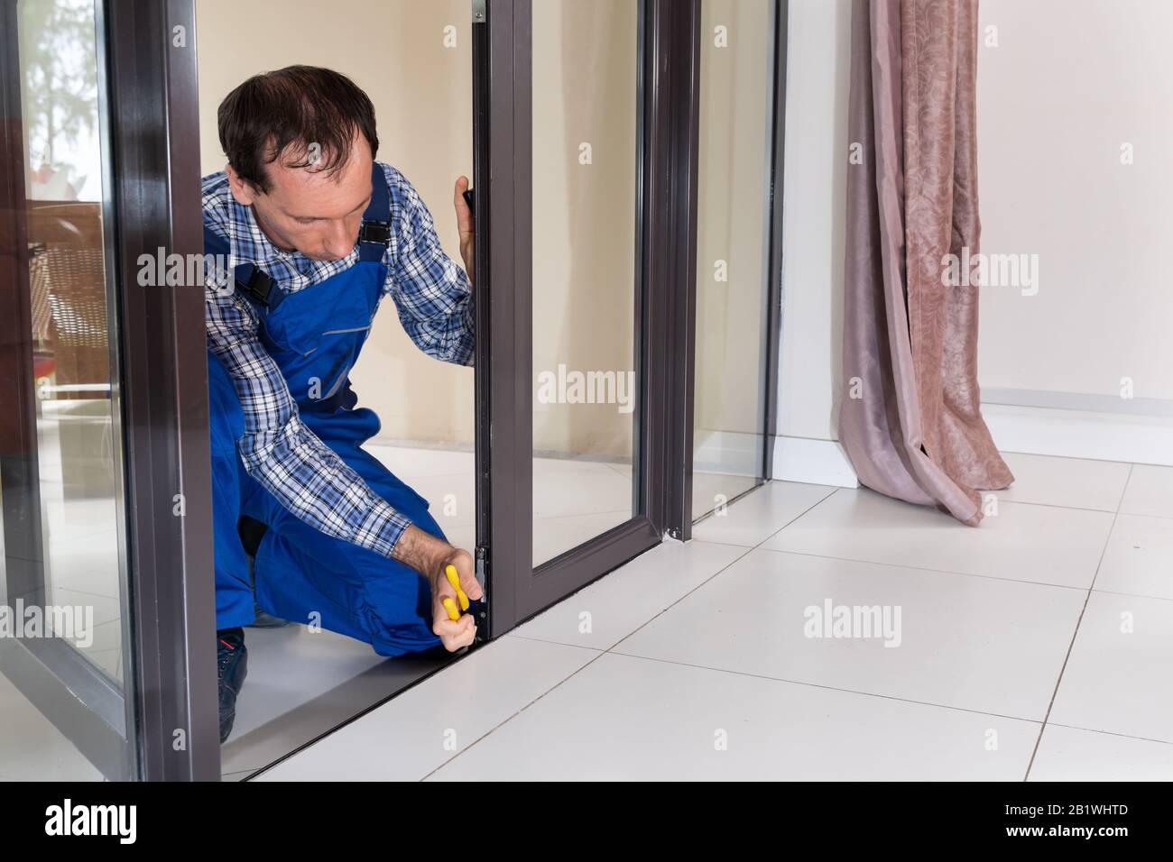 Close-up Of A Repairman's Hand Fixing Window Stock Photo