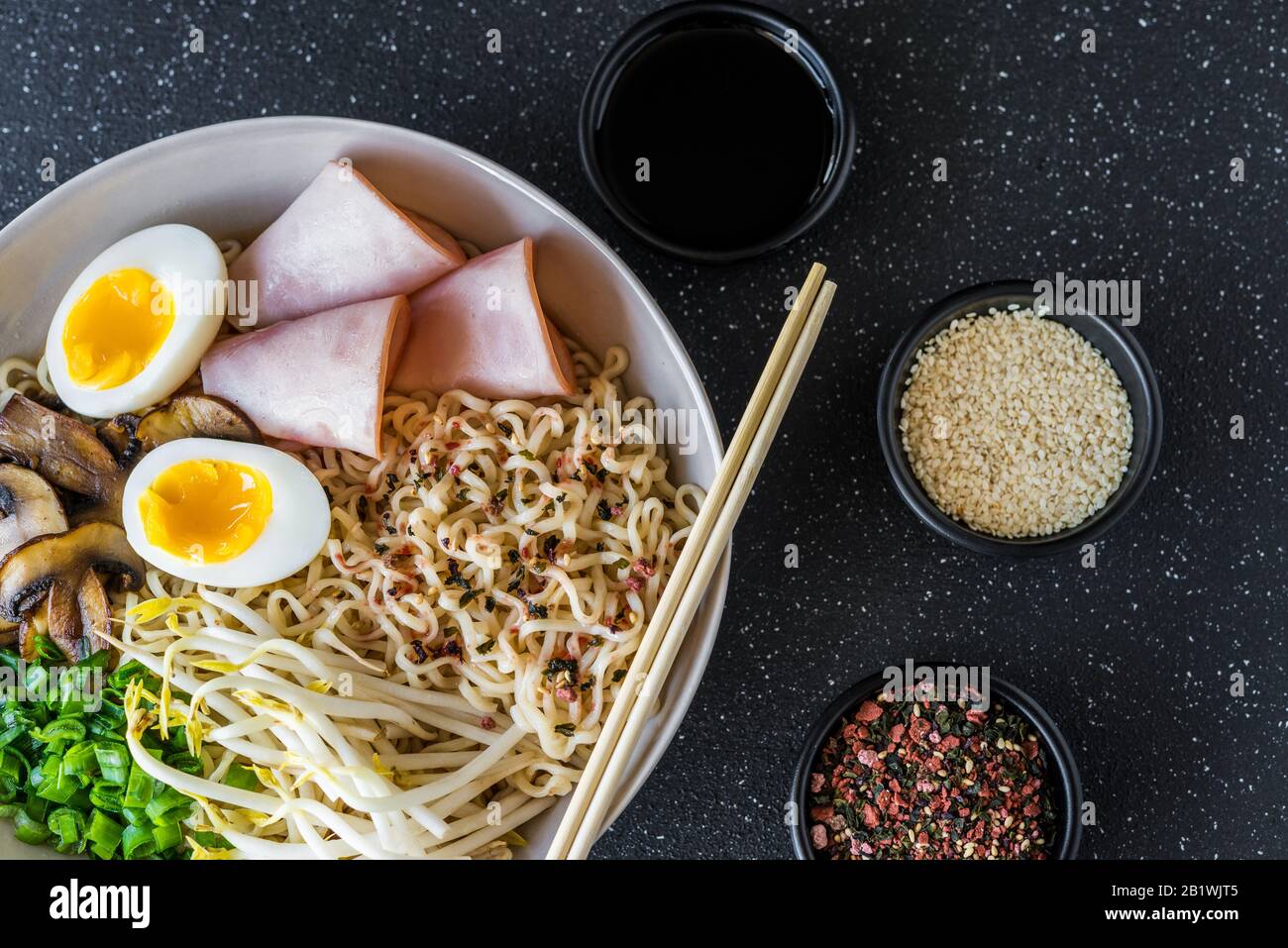 A bowl of asian food ramen noodles soup against black stone background. Stock Photo