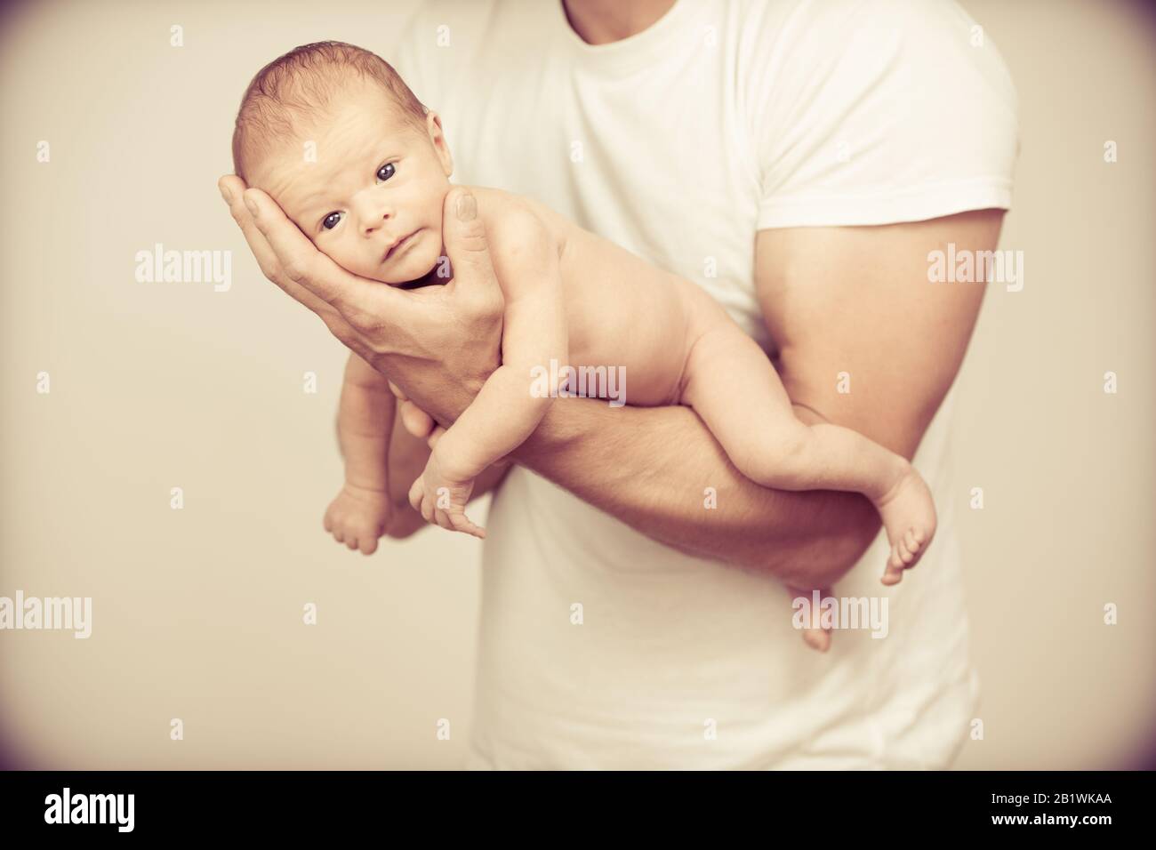 Father holding new born baby on his arm Stock Photo