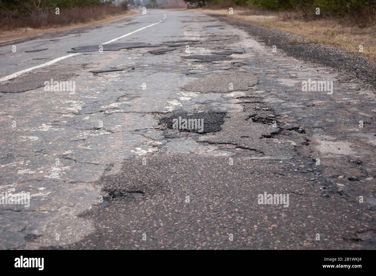 photo of a bad road, destroyed gray tarmac,  closeup Stock Photo