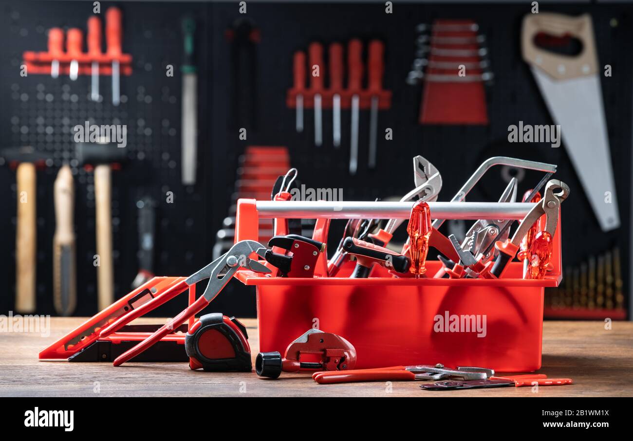 Toolbox With Different Worktools Against Wall With Tools Stock Photo