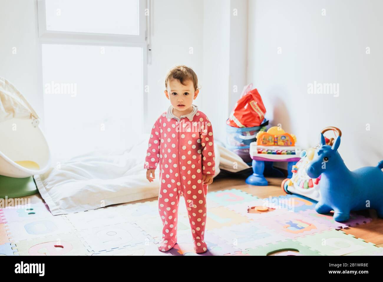 Scared girl looking at camera standing in her room. Stock Photo