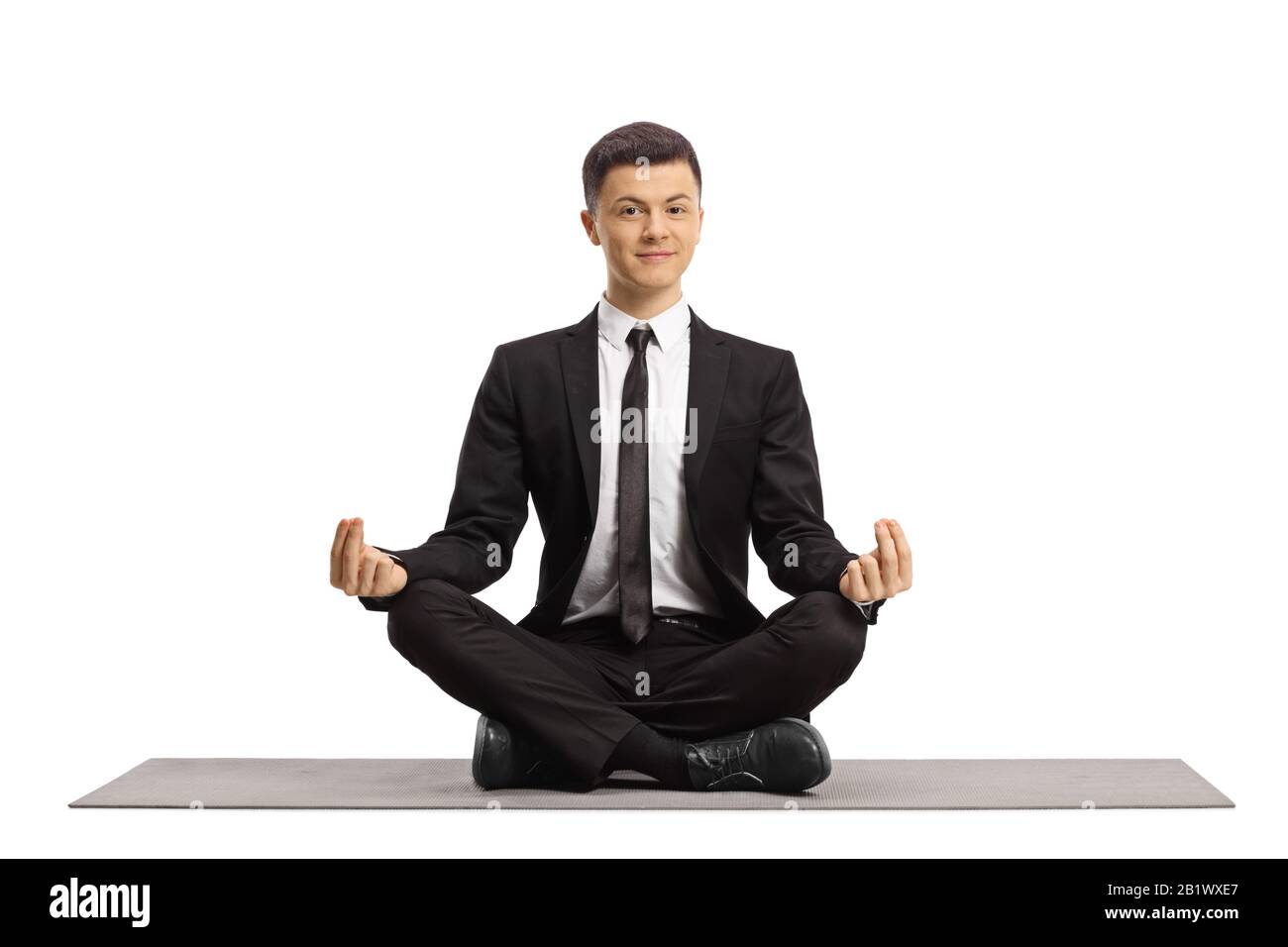 Young guy in a black suit sitting with crossed legs and making a ...