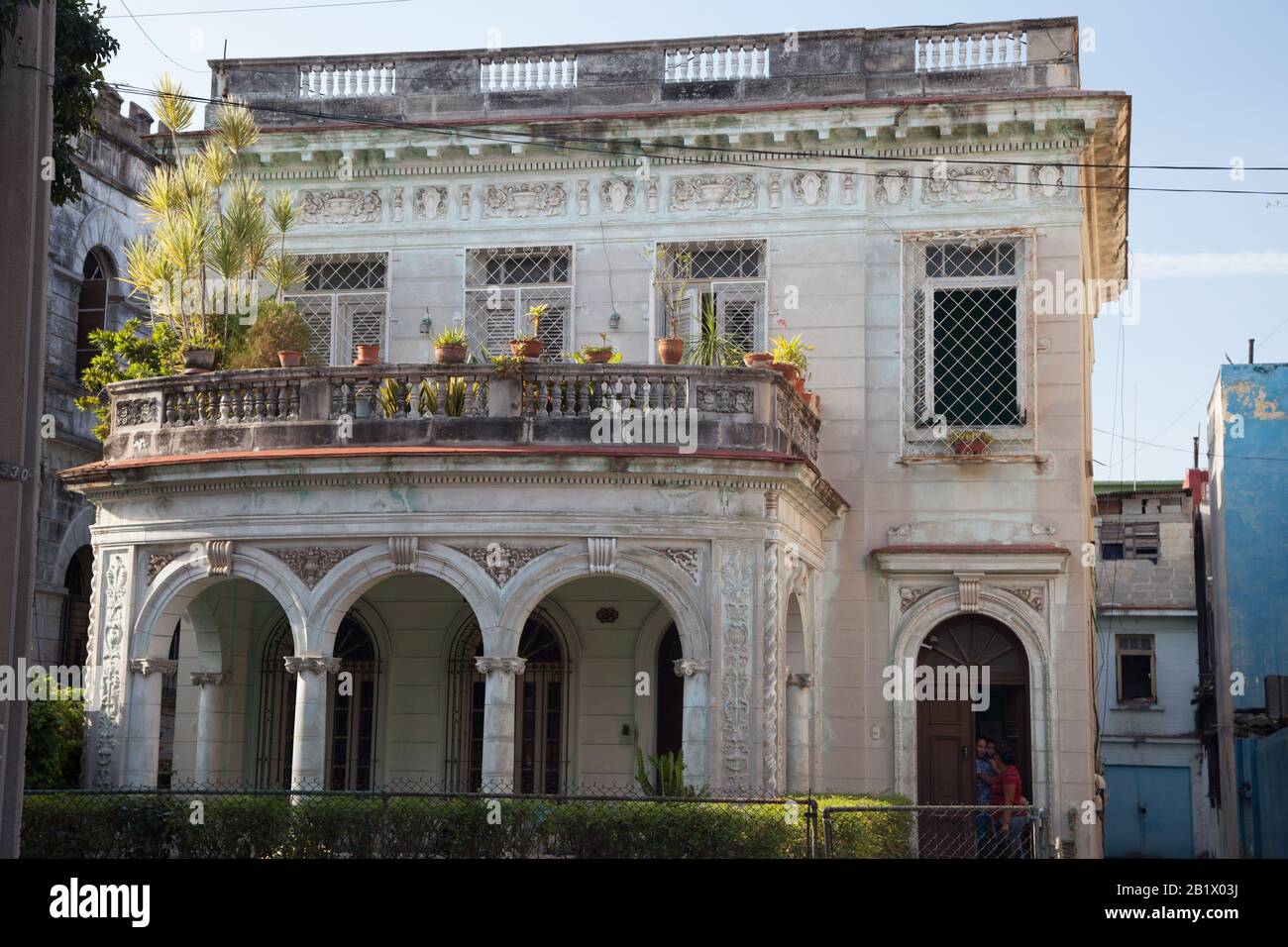 A beautiful historic home in Havana, Cuba with arches, a deck, and exterior landscaping Stock Photo