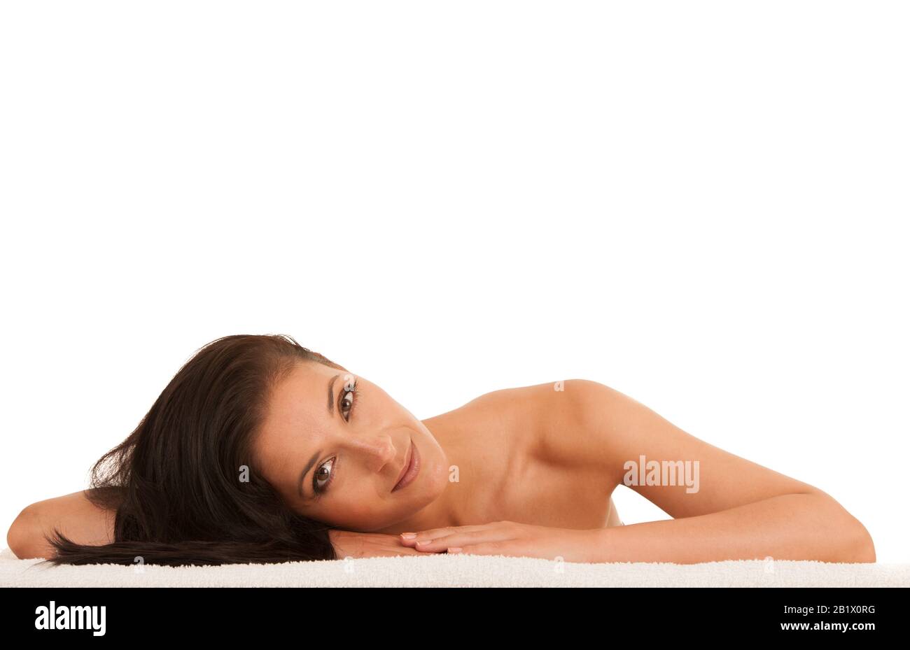 Skin care - beautiful young woman rests on a towel after having skin care treatment isolated over white Stock Photo