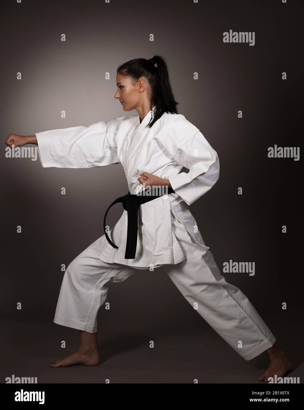 Woman in white  kimono punch hard in the air -  a karate martial art girl Stock Photo