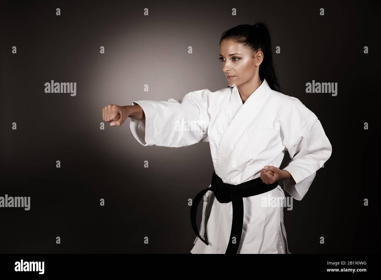 Woman in white  kimono punch hard in the air -  a karate martial art girl Stock Photo