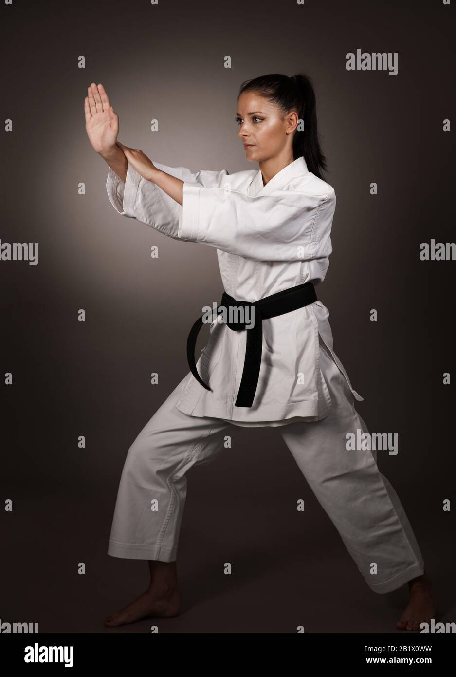 Woman in white  kimono punch hard in the air -  a karate martial art girl Stock Photo