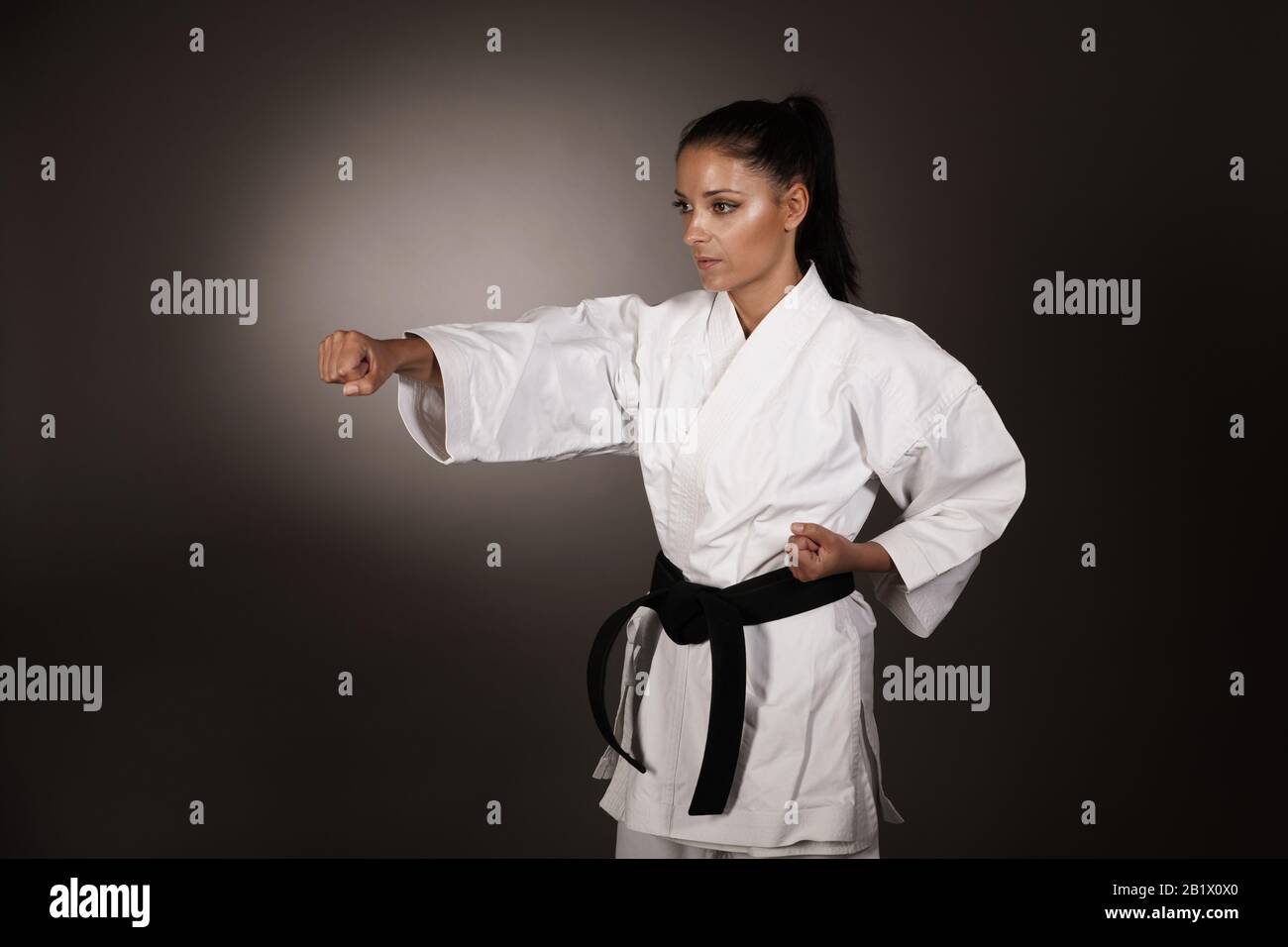 Woman in white  kimono punch hard in the air -  a karate martial art girl Stock Photo