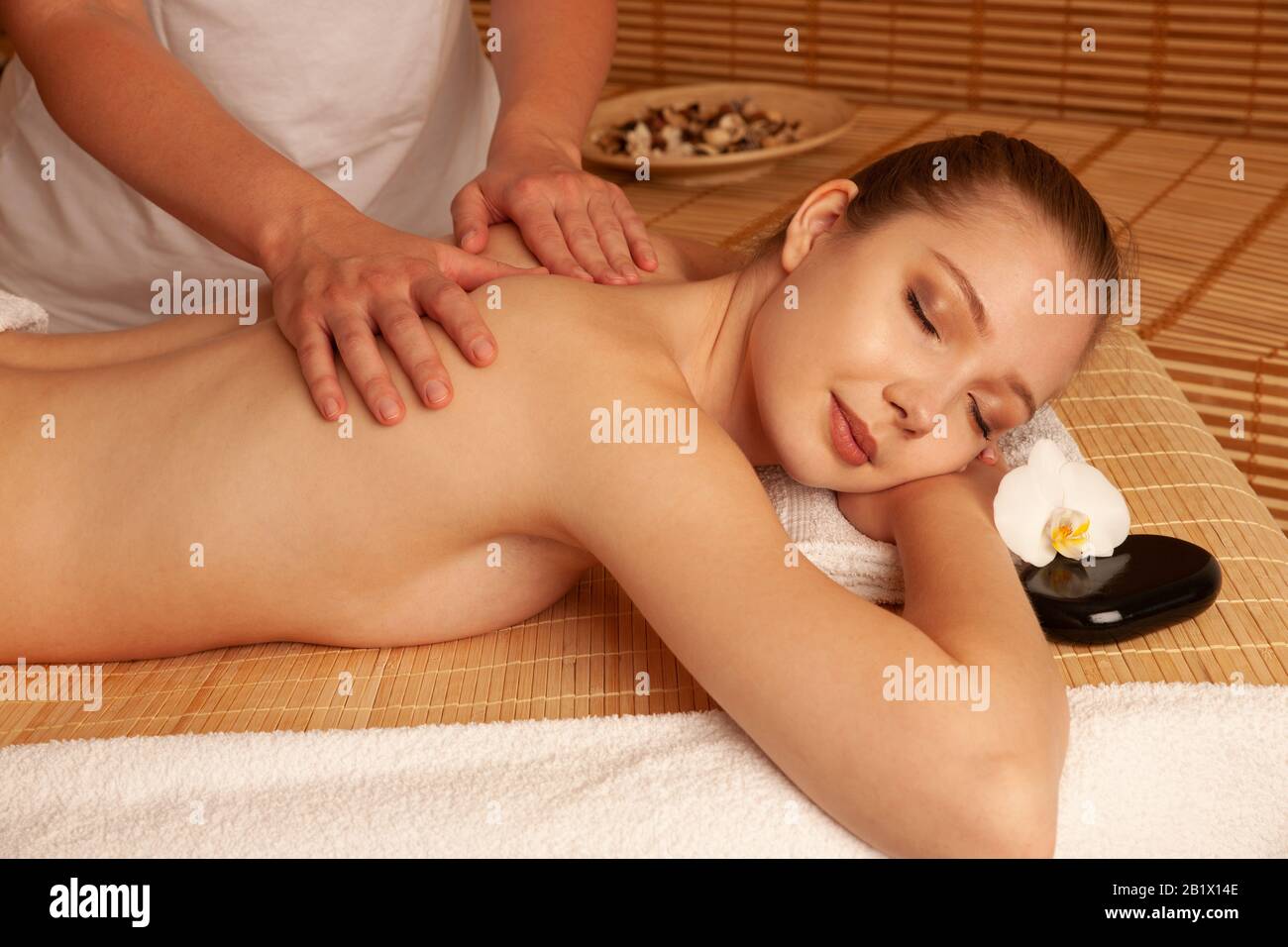 Beautiful young woman having a massage treatment in spa salon - wellness . Stock Photo