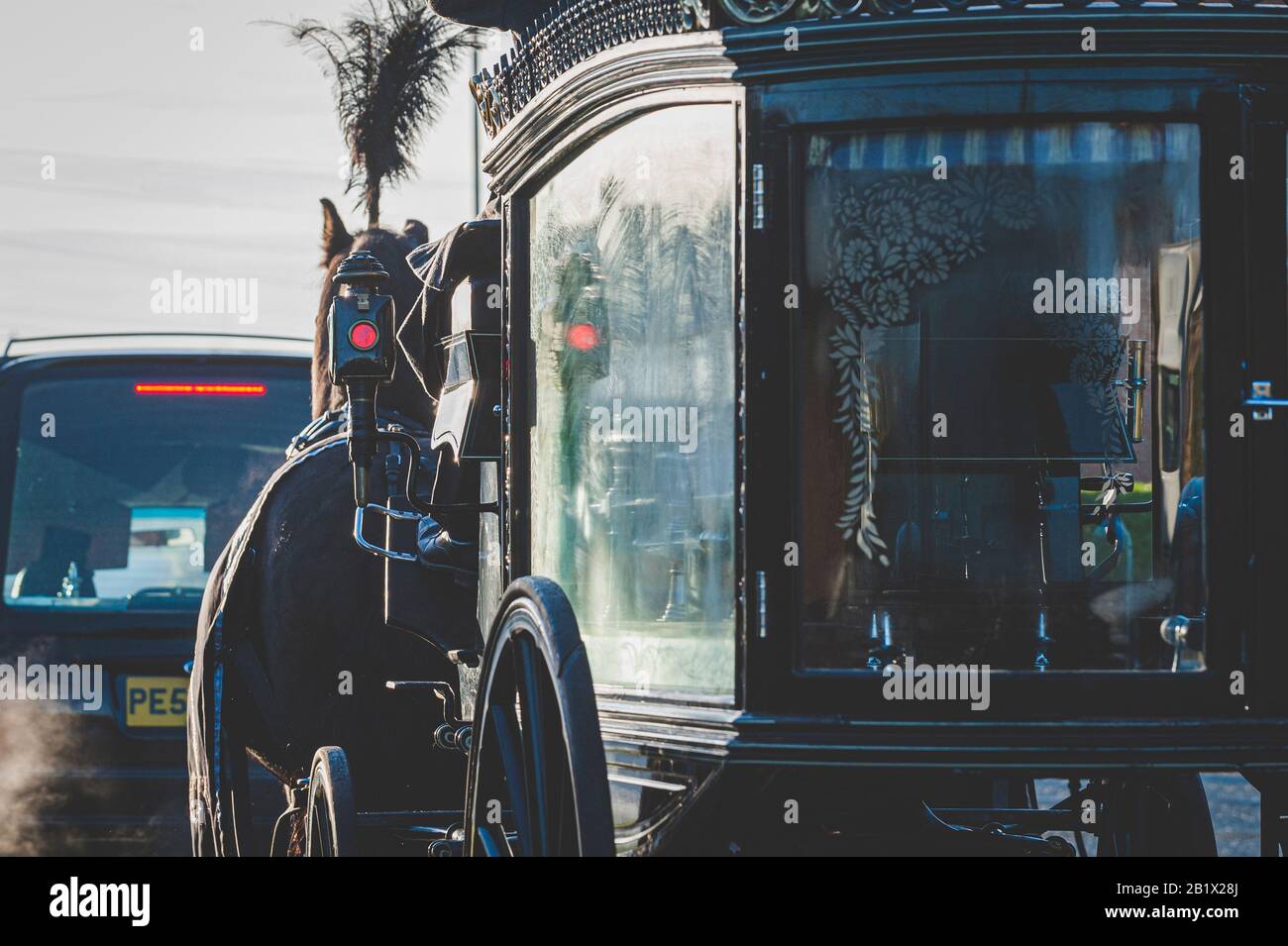 Rear view of a horse drawn hearse taking part in a funeral cortege. Stock Photo