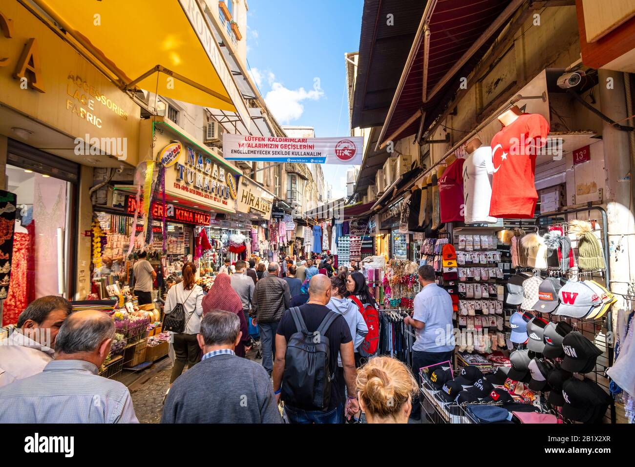Local Turks spend a busy day shopping the narrow colorful alleys in the outdoor Eminonu Bazaar Marketplace in Istanbul, Turkey. Stock Photo