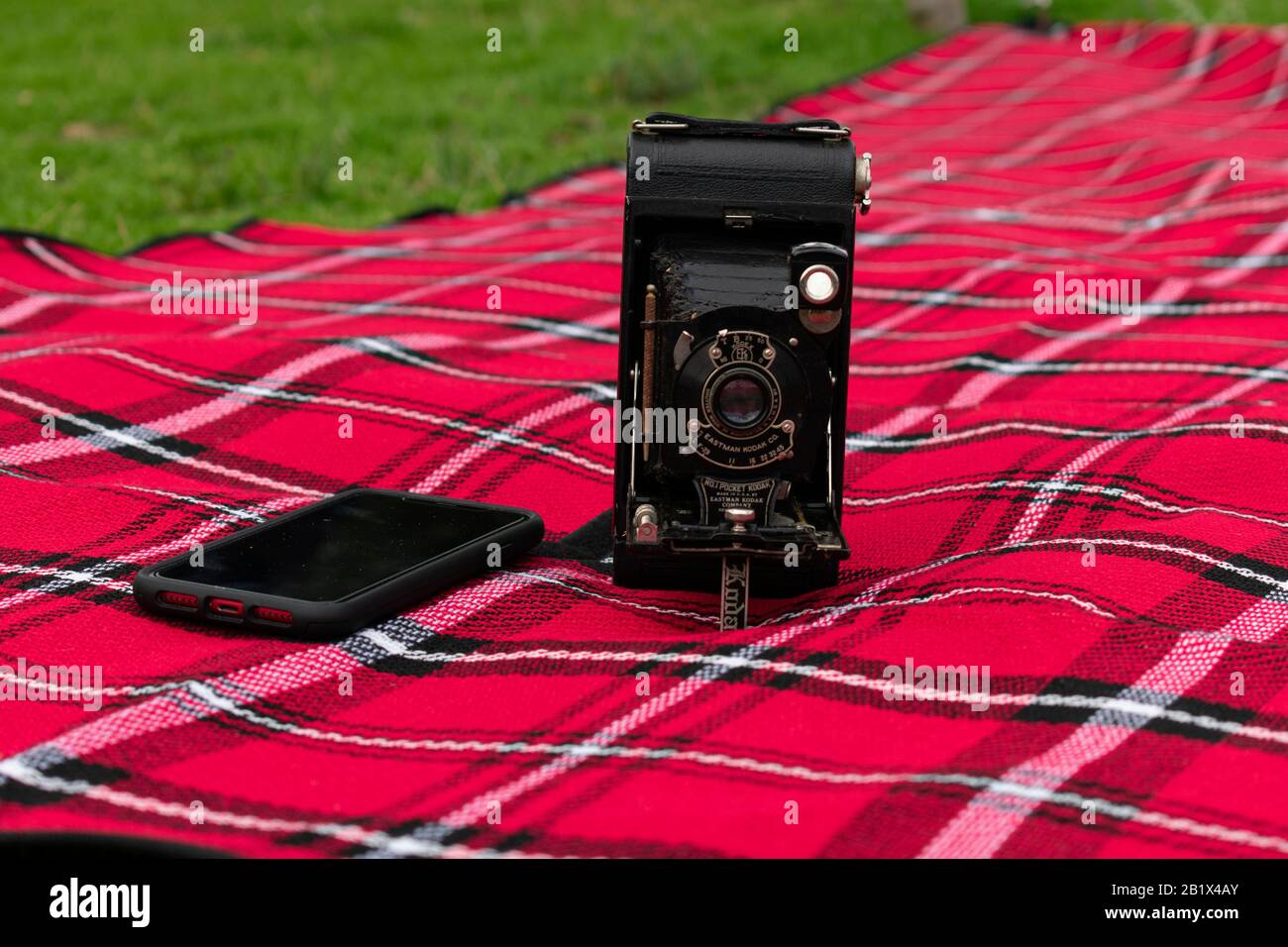 old camera with a modern camera phone on a picnic rug Stock Photo