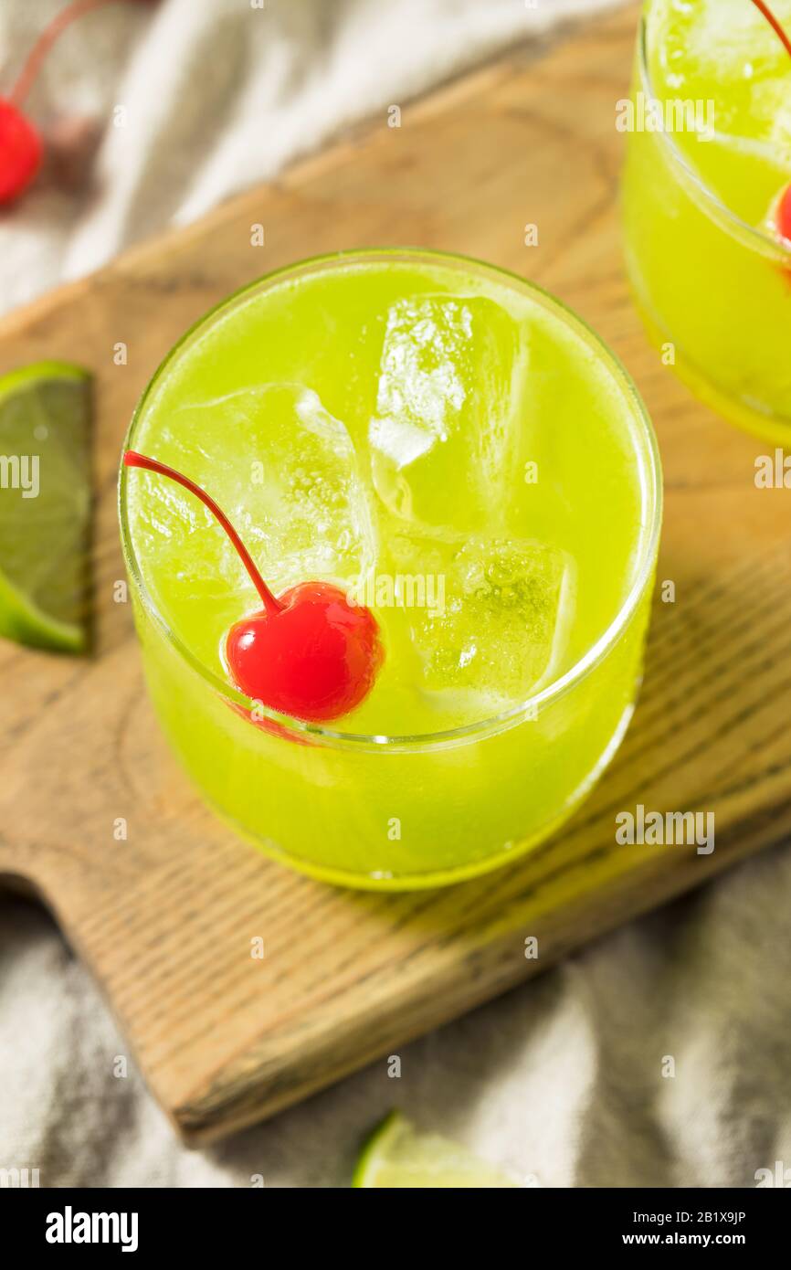 Homemade Green Melon Midori Sour with a Red Cherry Stock Photo