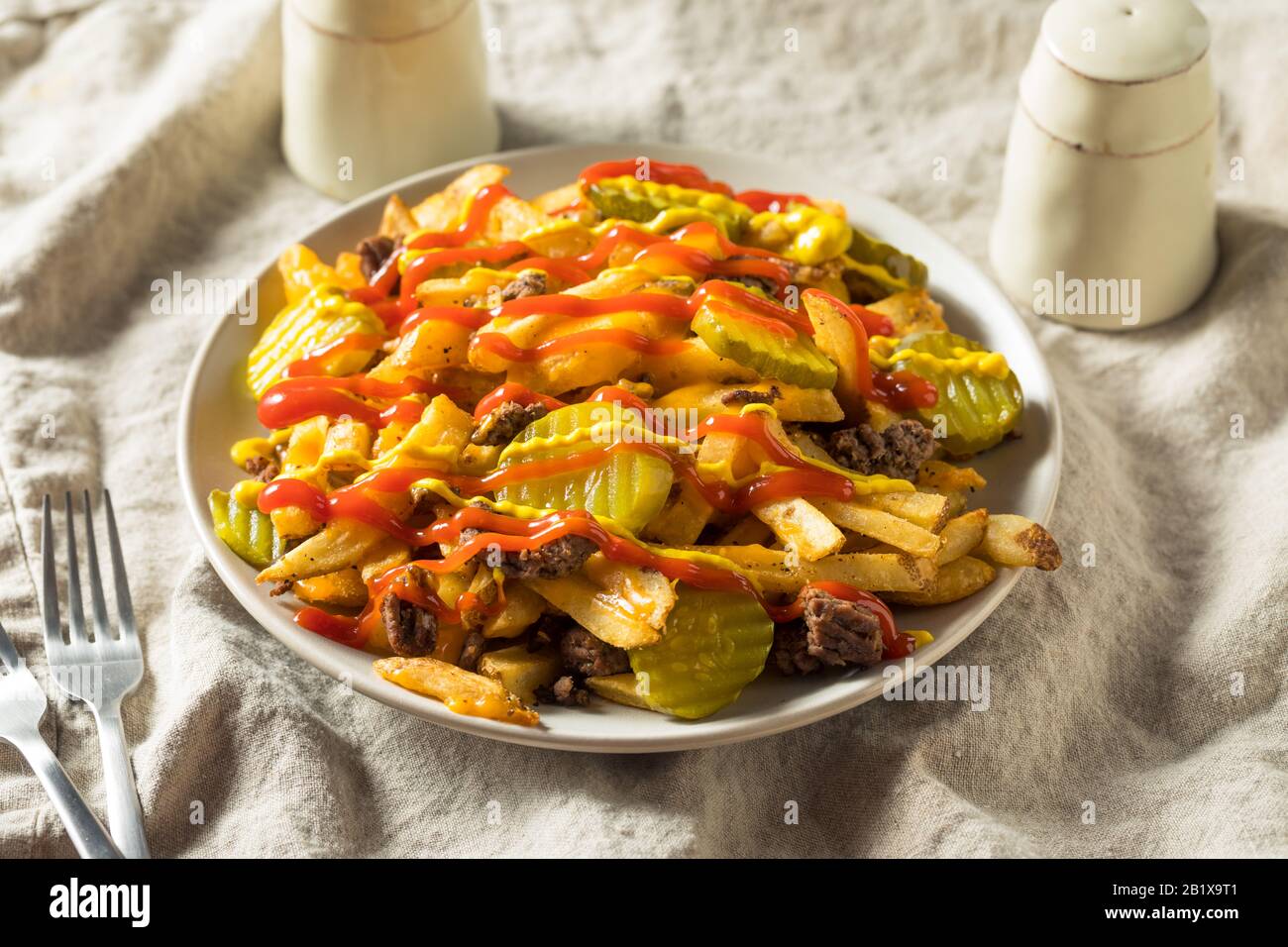 Homemade Loaded Cheeseburger Cheese Fries with PIckles and Ketchup Stock Photo