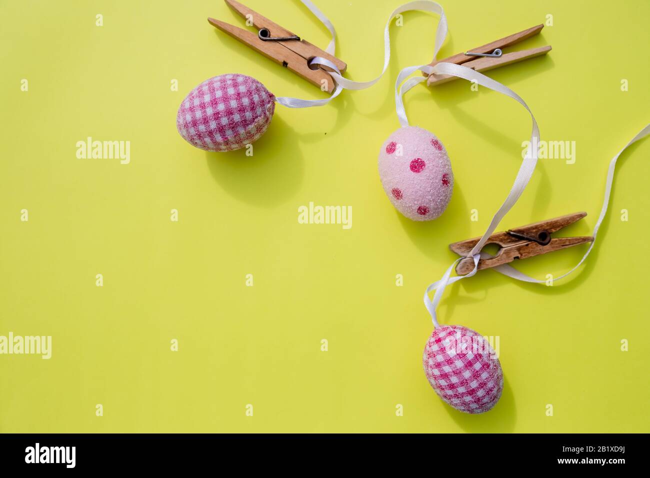 Happy Easter.Greeting card with easter eggs hanging on clothesline, rustic background. Stock Photo