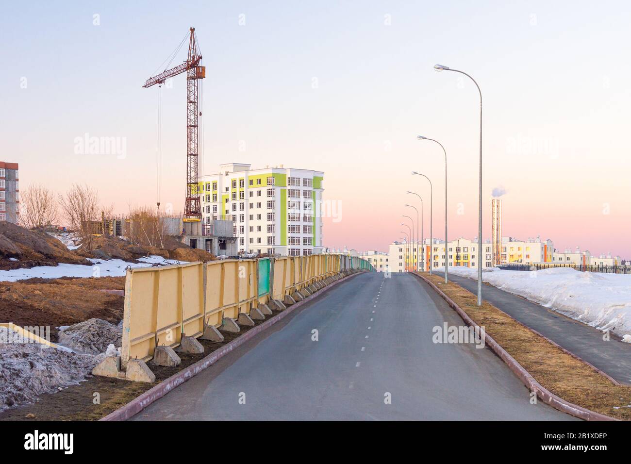 construction of monolithic public and residential buildings using tower cranes building noise in a residential area of low-rise buildings Stock Photo