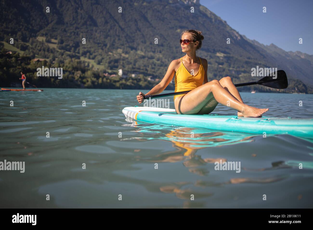 SUP Stand up paddle board concept Pretty, young woman paddle boarding