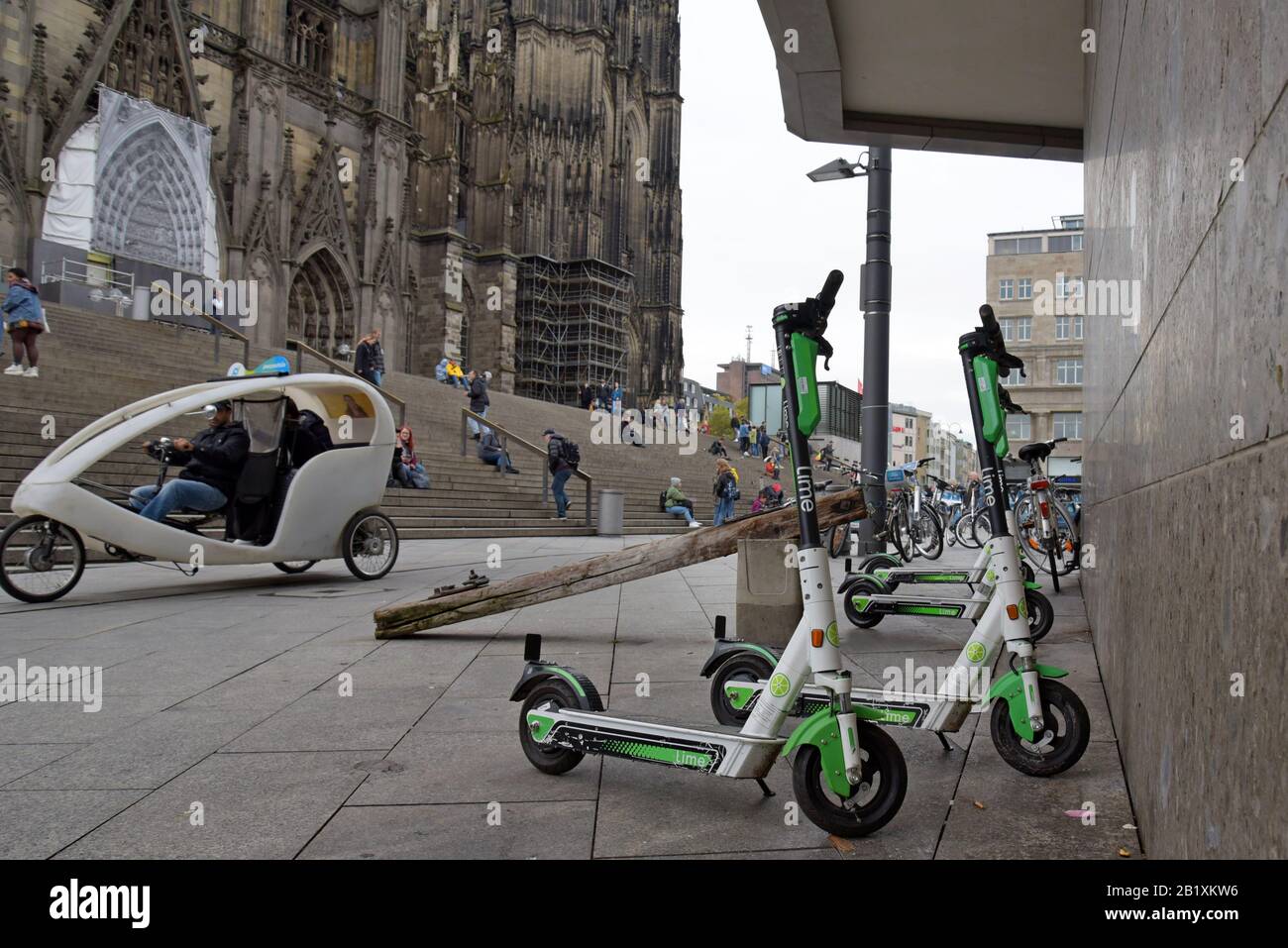 Lime S dockless electric scooters parked with hire bicycles outside Cologfne Cathedral, Germany Stock Photo