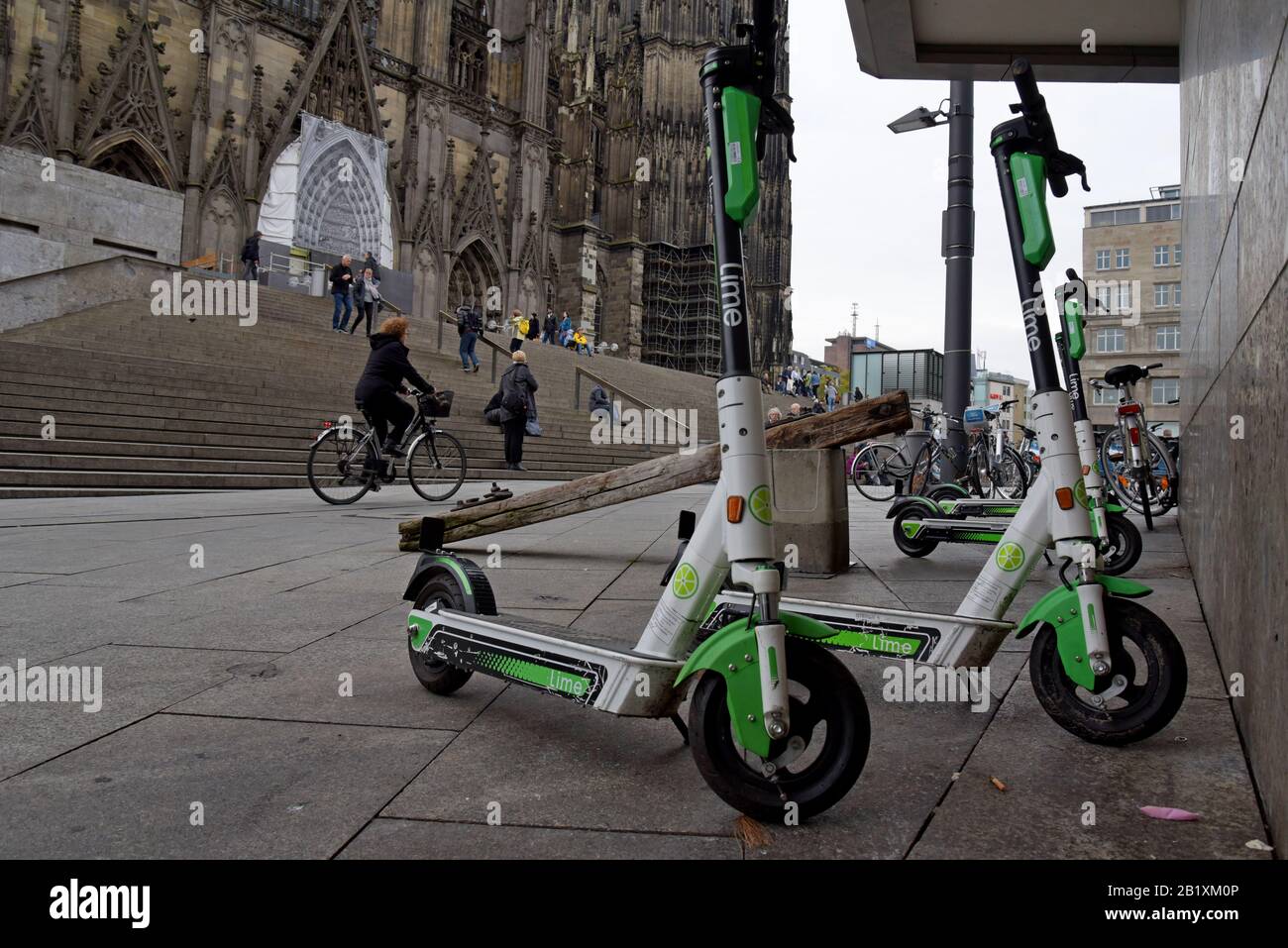 Lime S dockless electric scooters parked with hire bicycles outside Cologfne Cathedral, Germany Stock Photo