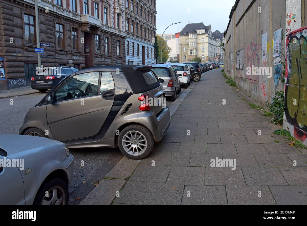 Smart Car Fortwo parked sideways with wheels on the pavement in an on street parking space in Hamburg, Germany. October 2019 Stock Photo