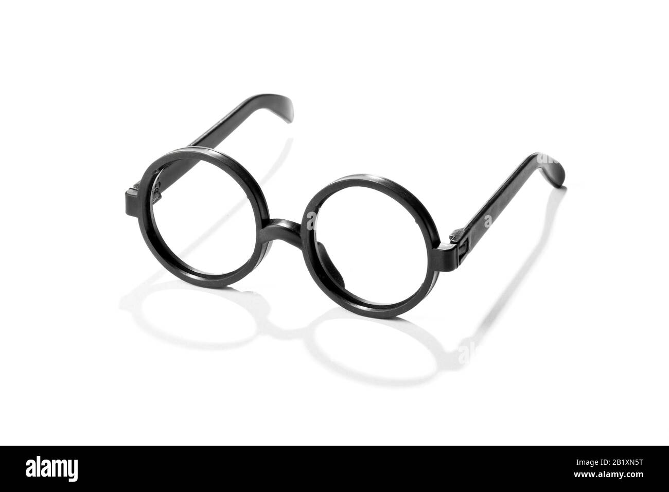 Pair of round vintage plastic reading glasses with black frames casting a shadow on a white background Stock Photo