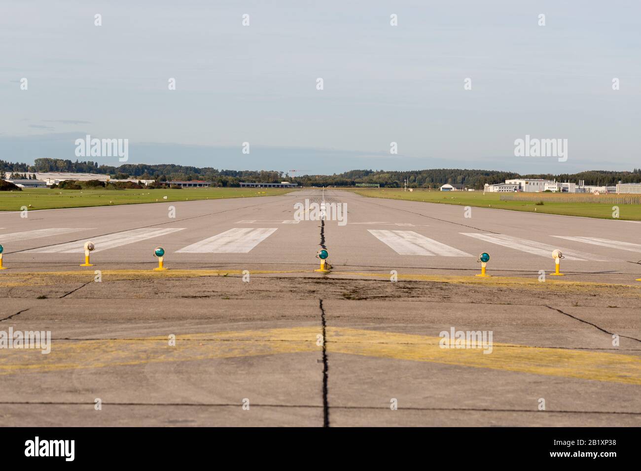 Centered view on an empty runway / landing strip. An airfield of an airport Close to Munich. Concept for journey, travel, fly away, freedom, distance. Stock Photo