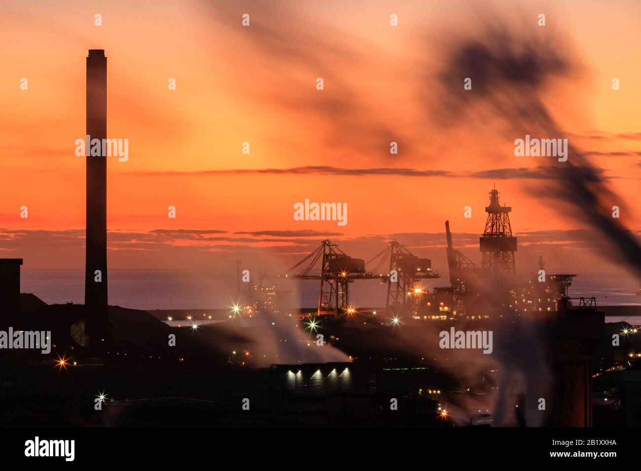 Port Talbot steel works emitting clouds of steam in the evening light Port Talbot Swansea Glamorgan Wales Stock Photo